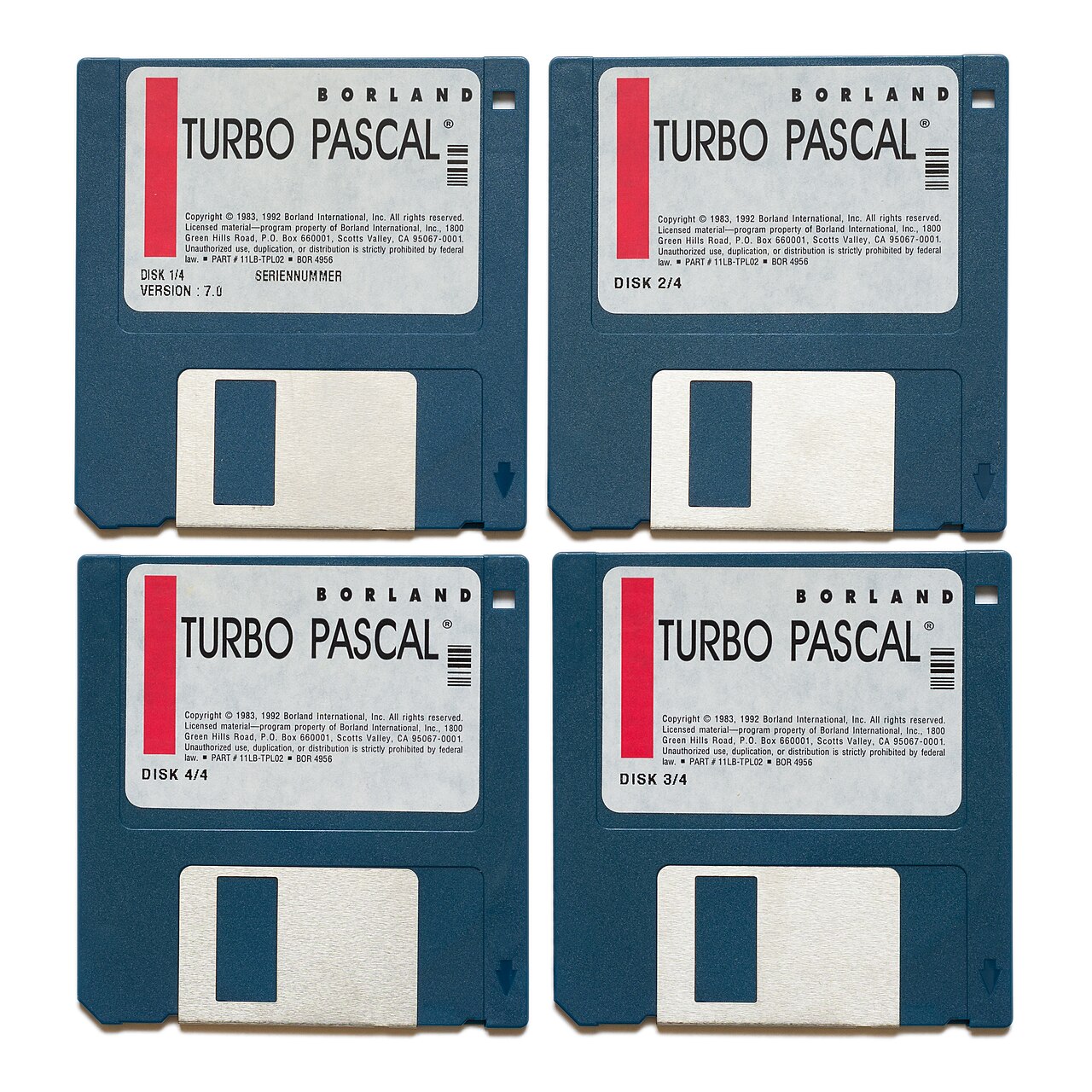 Quatro disquetes azuis de 3,5 polegadas da Borland com etiqueta Turbo Pascal, numerados de 1 a 4, versão 7.0, sobre fundo branco.