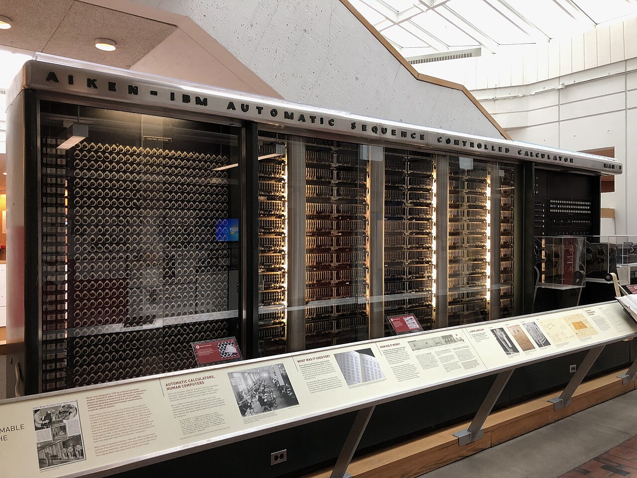 O Harvard Mark I exposto em Harvard: painel longo de vidro com o letreiro Aiken-IBM Automatic Sequence Controlled Calculator e fileiras de relés e contadores