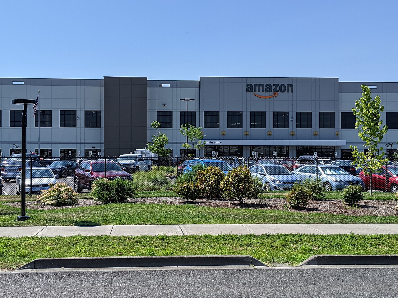 Fachada de um grande armazém da Amazon, de paredes lisas e portas de carga, vista da rua, em Troutdale, no Oregon.