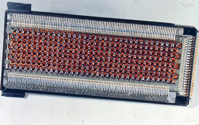 Módulo de memória fixa do computador da Apollo visto de cima, com fios de cobre trançados em fileiras de núcleos de ferrite.